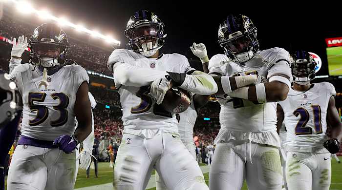 A group of Ravens defenders flex in the end zone after an interception